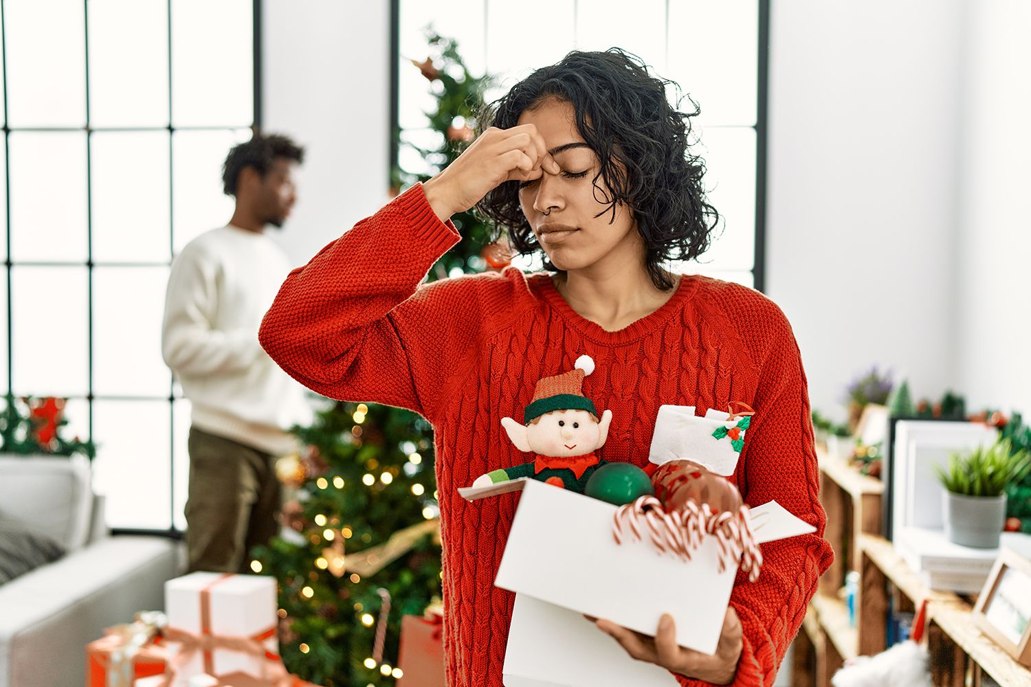 Woman holding Christmas decorations looking stressed