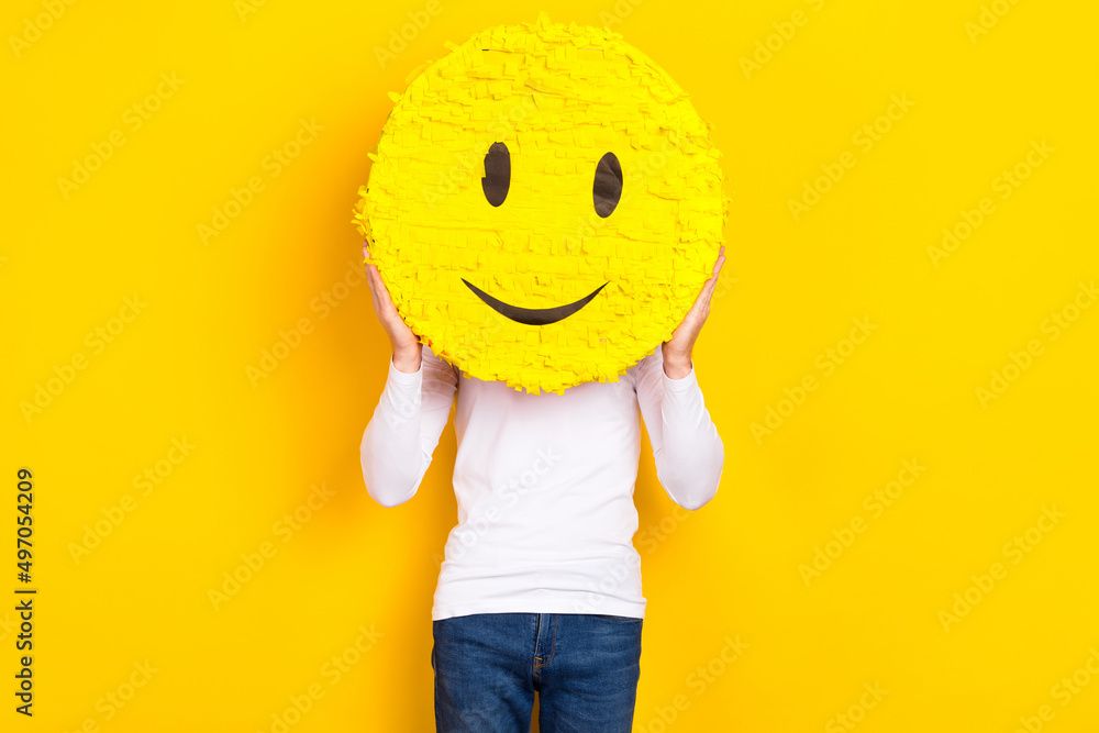 Person holding large yellow smiley face on yellow background
